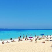 Beach scene with people enjoying sun and sand.