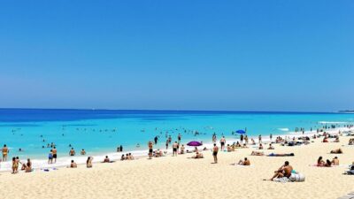 Beach scene with people enjoying sun and sand.