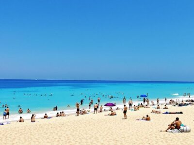 Beach scene with people enjoying sun and sand.